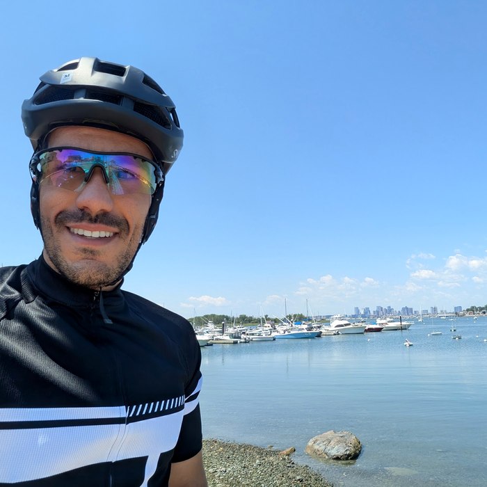 Lee on a bike ride along the harbor with the Boston skyline behind