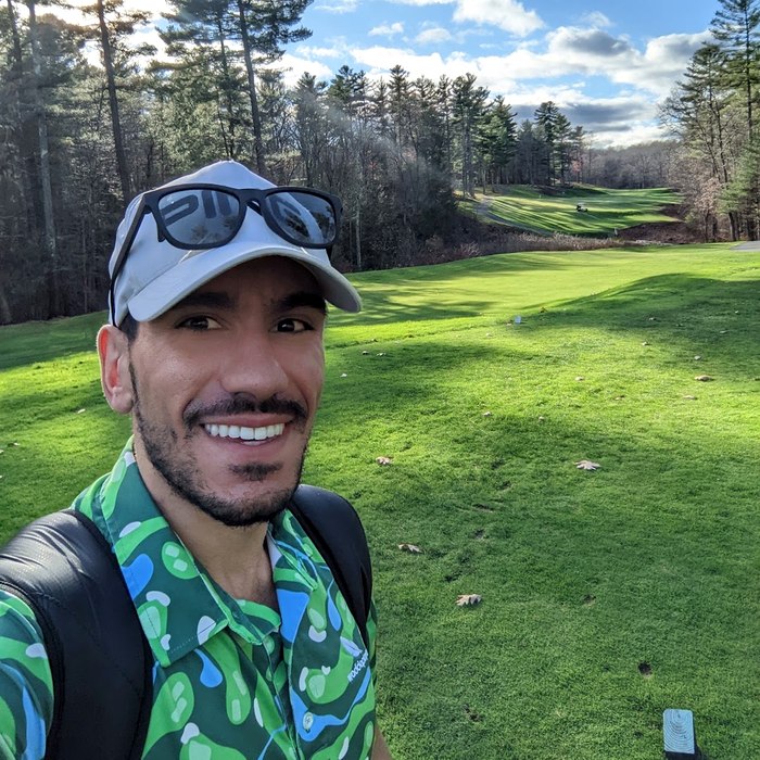 Lee on the tee box of a tree-lined golf hole